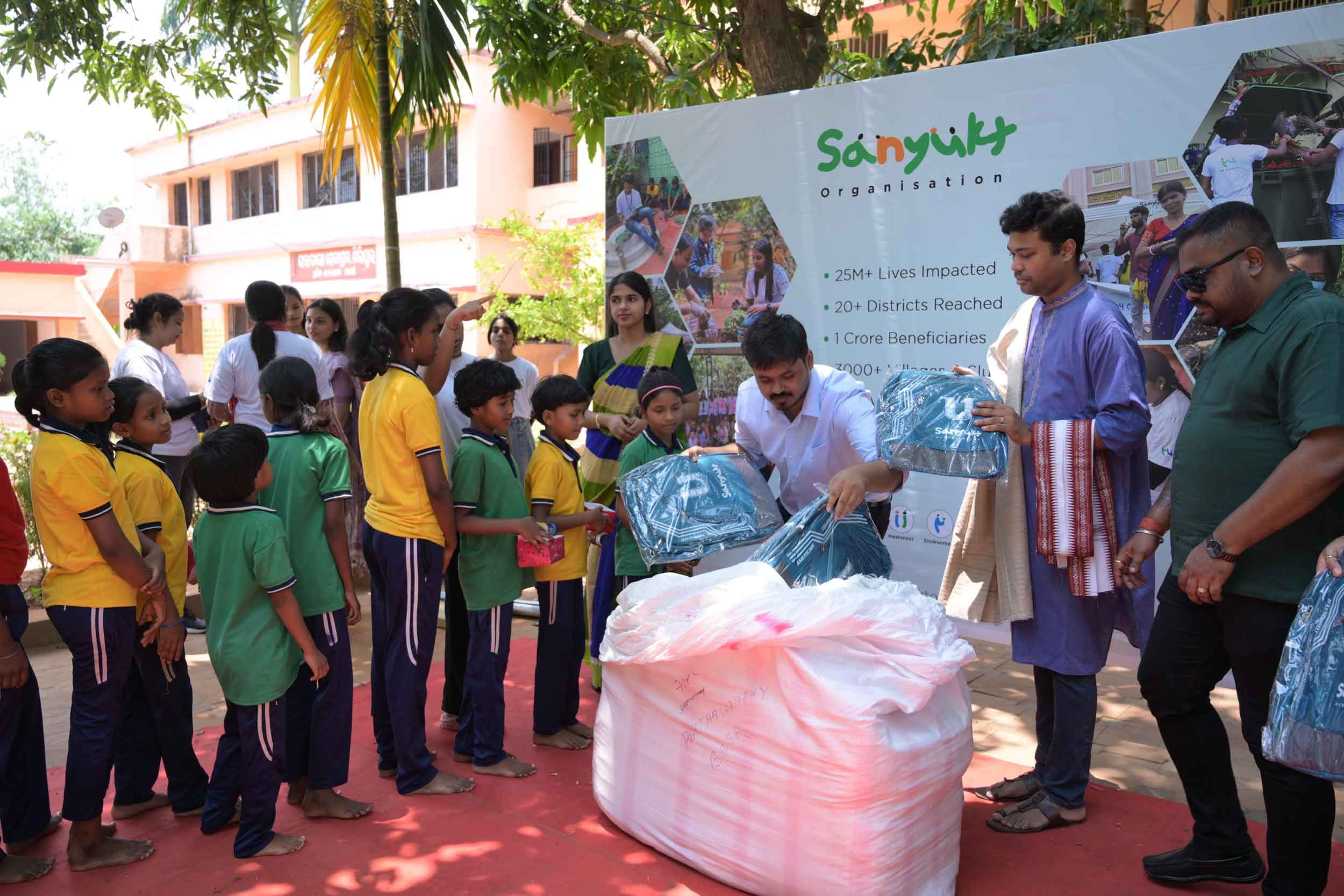 Sanyukt team distributing school backpacks to children under a collaboration initiative